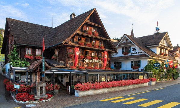 Ein traditionelles Holzhaus mit einem Schild, auf dem "Inniss Chalot" und "Astrid Hall" stehen.