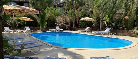 Piscine extérieure, parasols de plage, chaises longues