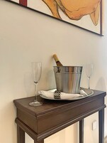 Ein Tisch mit einem Champagnerkühlbecher, zwei Gläsern und einer Serviette.