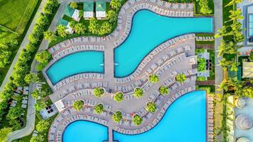 Een binnenzwembad, een buitenzwembad, parasols voor strand/zwembad