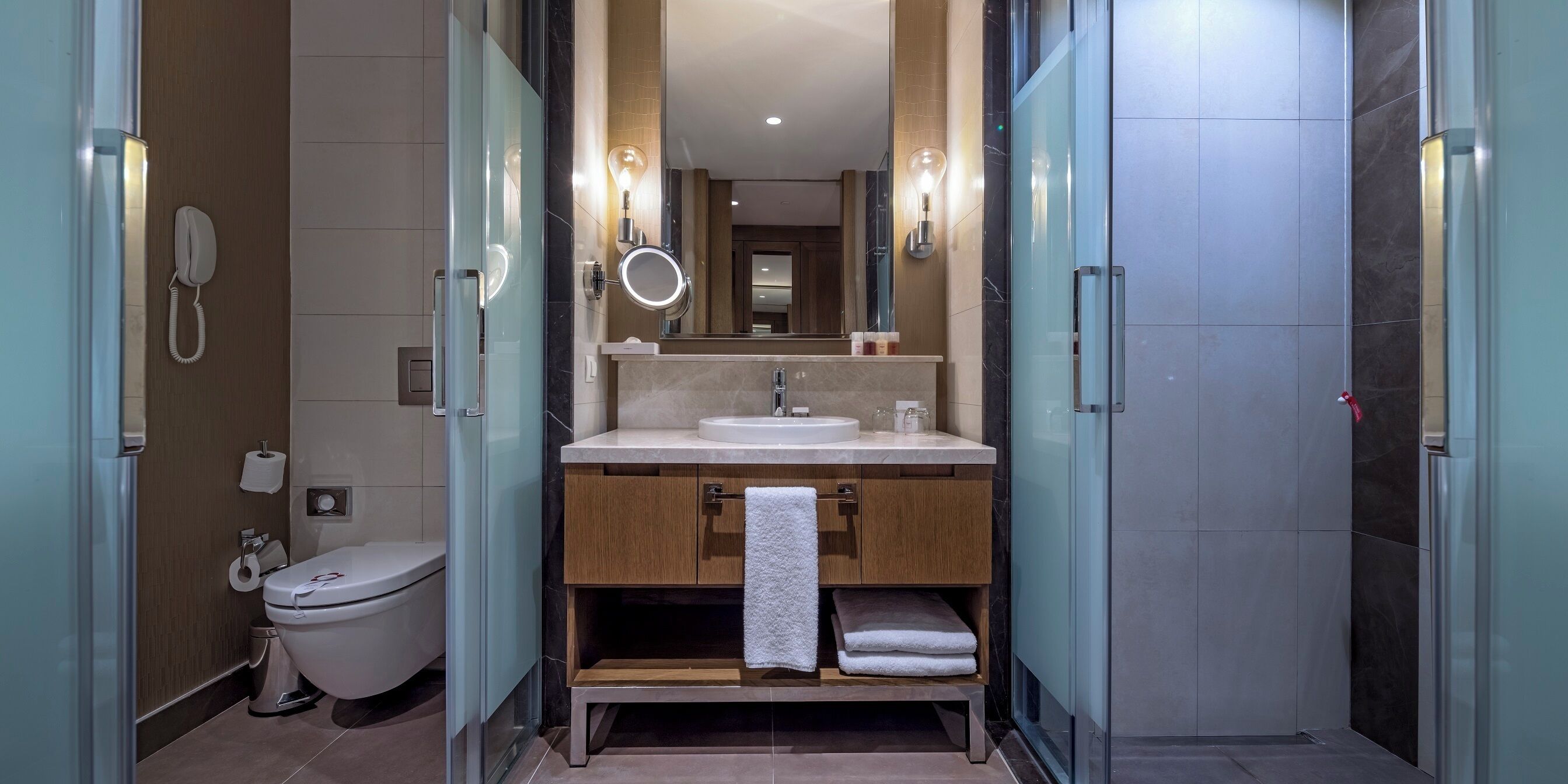 Een moderne badkamer met toilet, wastafel en spiegel.