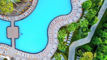 Una piscina techada, una piscina al aire libre, sombrillas