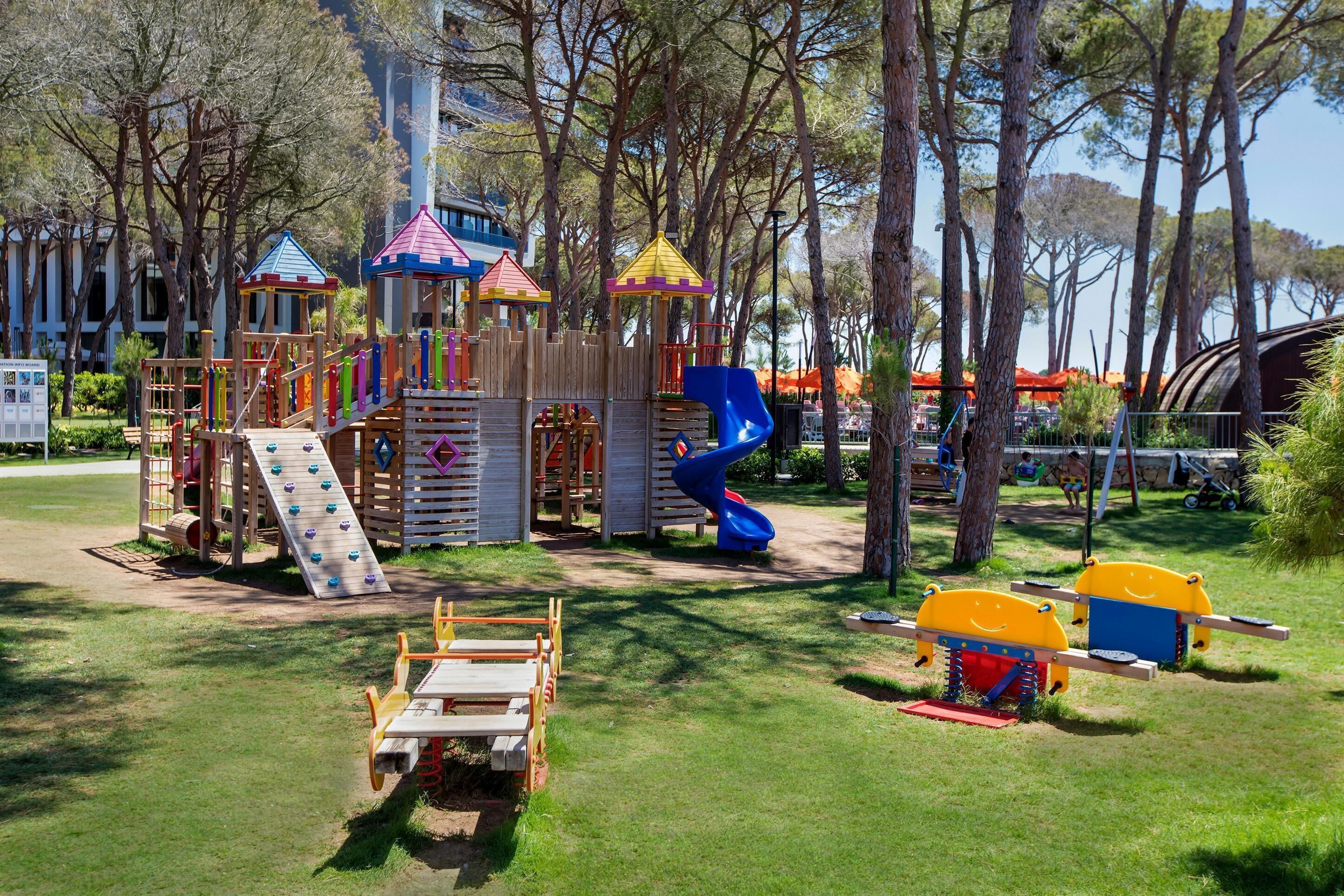 A playground with various play structures including slides and climbing areas.