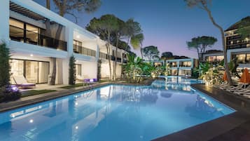 Una piscina cubierta, una piscina al aire libre, sombrillas, tumbonas