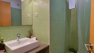 Un baño con lavabo, espejo y ducha.