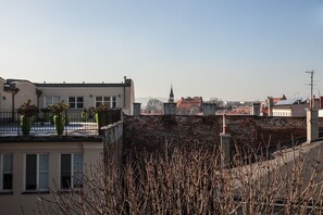 A building with a brick facade, large windows, and a balcony with potted plants. - EchoDom 3 Apartments (Kraków)