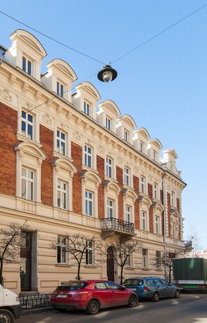 Um edifício de vários andares com estilo arquitetônico clássico, apresentando uma série de janelas e varandas.