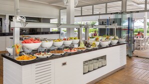 Zona de buffet con diferentes opciones de comida y un área de comedor con mesas y sillas.