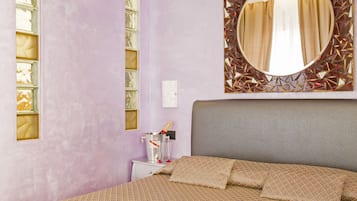 A bedroom with a bed, a nightstand, a mirror, and a decorative wall panel.