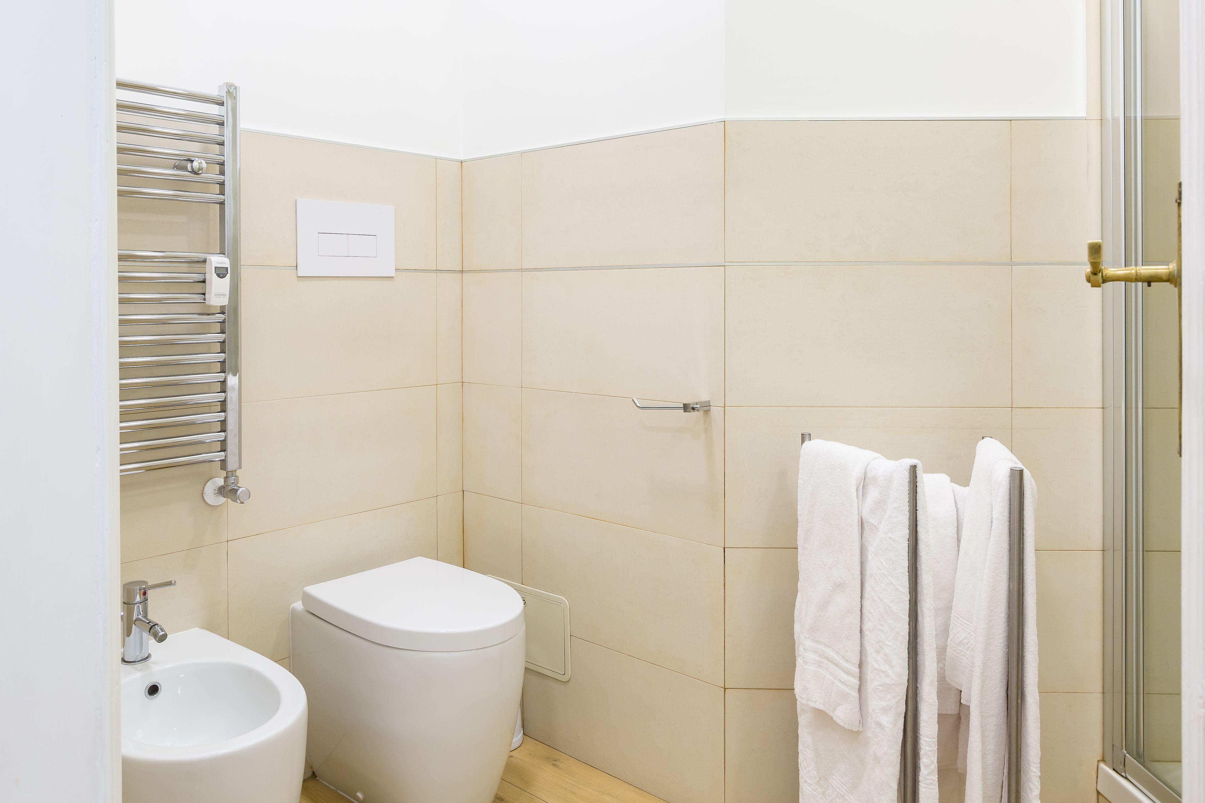 Un baño pequeño y limpio con inodoro, bidé y toallero.