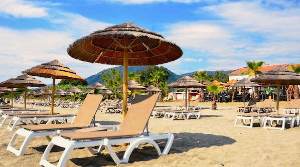 On the beach, sun-loungers, beach umbrellas, beach towels