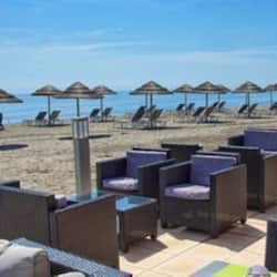 En la playa, sillas reclinables de playa, sombrillas, toallas de playa