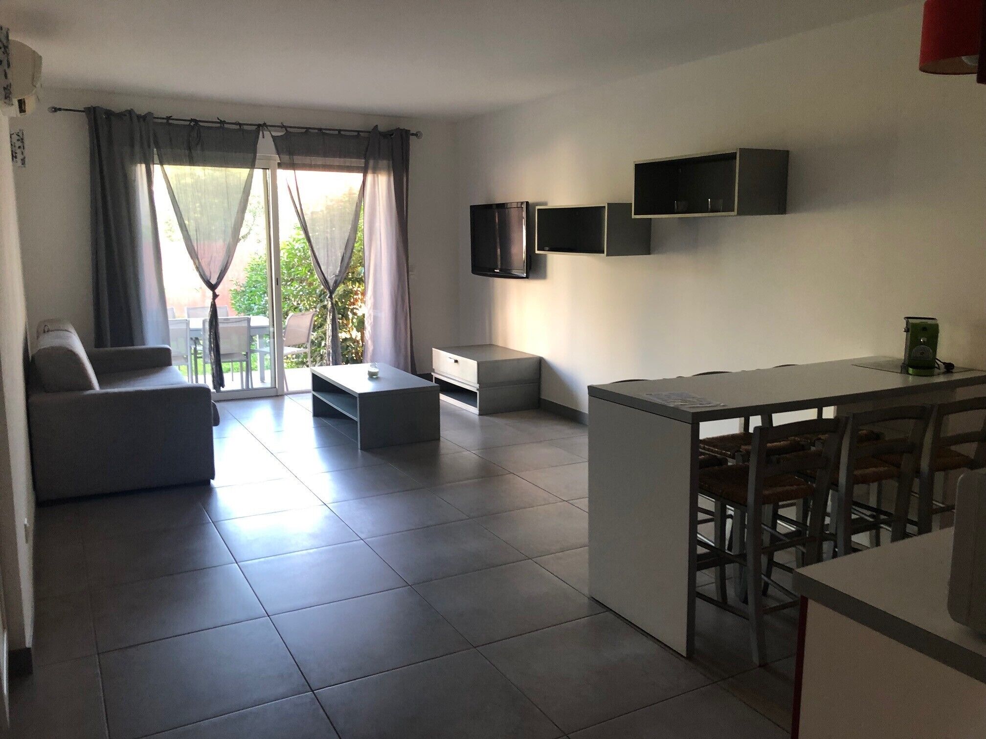 Una sala moderna con un sofá, una mesa de centro y un comedor con sillas.