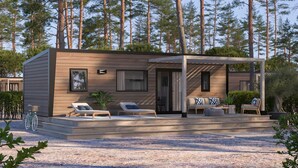 A modern cabin with a covered patio, outdoor seating, and a bicycle. - Résidence Marea Resort (Santa-Lucia-di-Moriani)