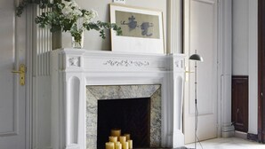 A grand room with a marble fireplace, white columns, and a framed picture above it. - Casa Abamita (Barcelona)
