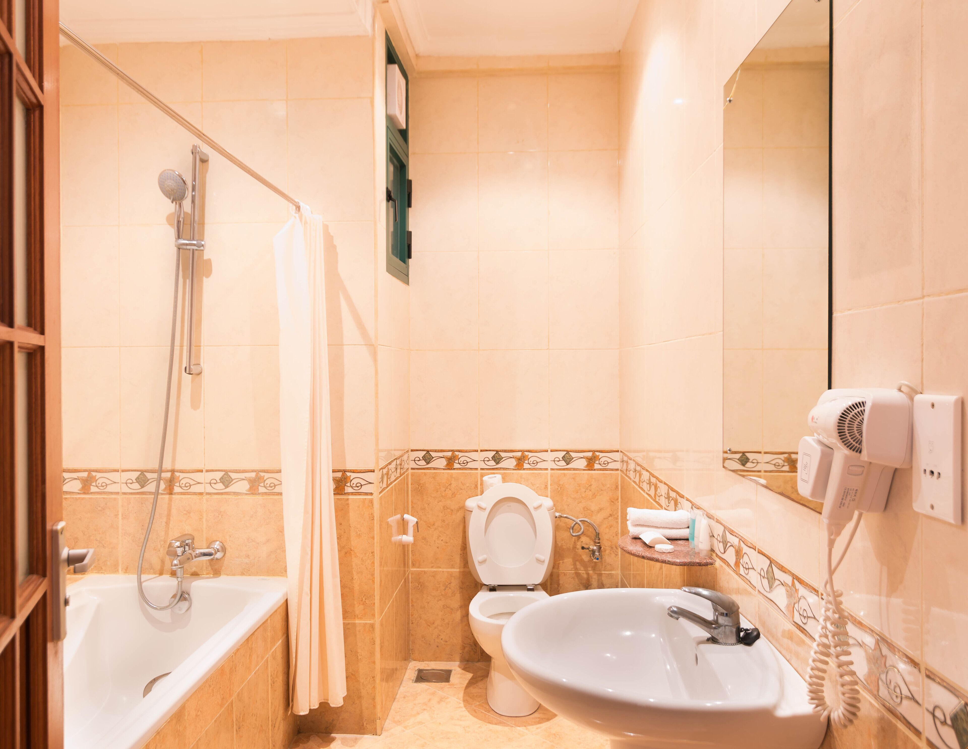 A bathroom with a bathtub, toilet, sink, and a shower.