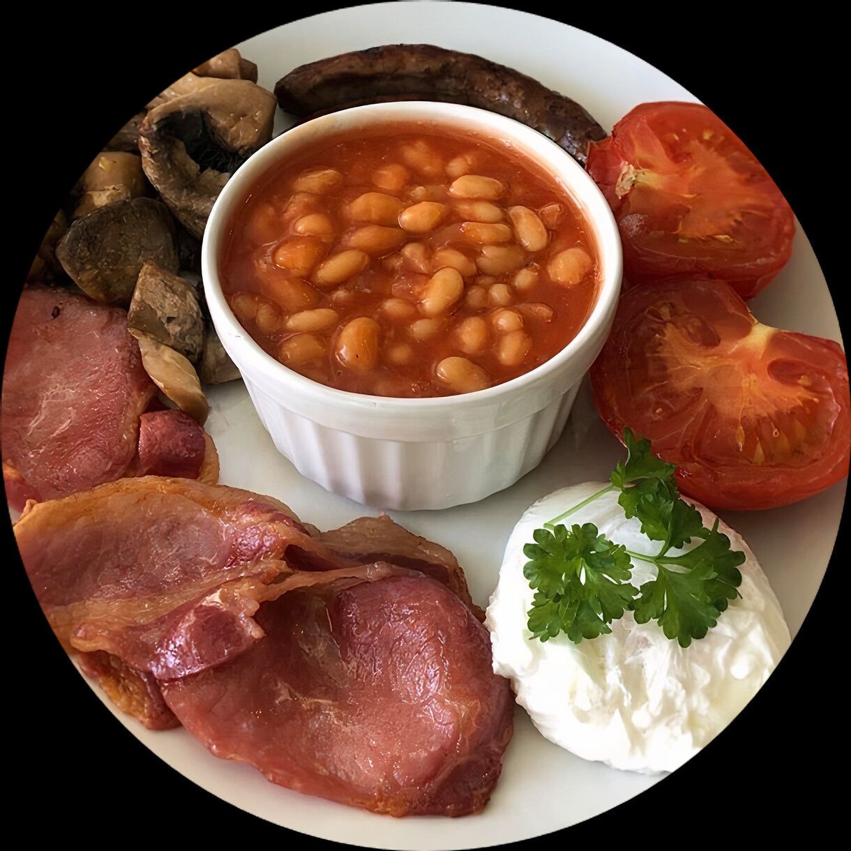 A plate with beans, tomatoes, mushrooms, bacon, and a dollop of cream.