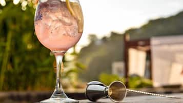 A cocktail glass with ice and a lemon slice on a table.