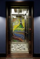 Un ascensor con un mural de colores en la pared.