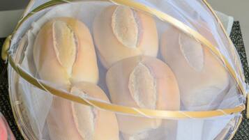 A mesh basket containing several bread rolls.