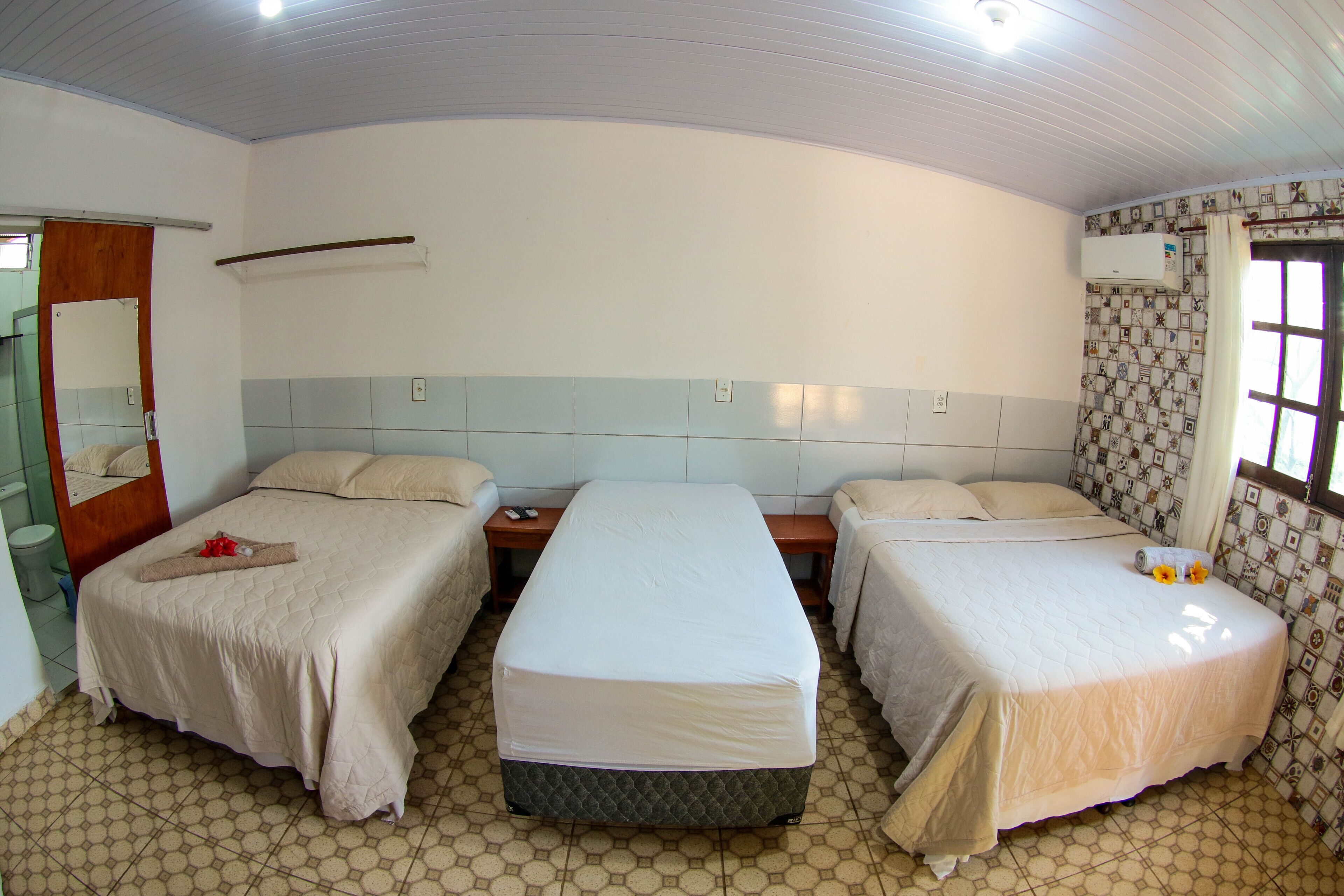 Una habitación de hotel con dos camas, un baño y un ventanal.