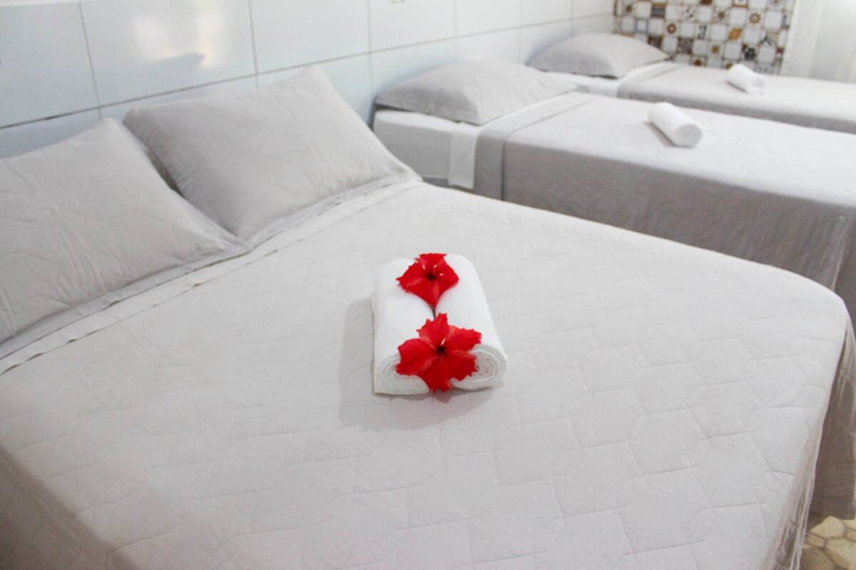 Une chambre d’hôtel avec deux lits simples, chacun recouvert d’une courtepointe blanche et doté d’oreillers.