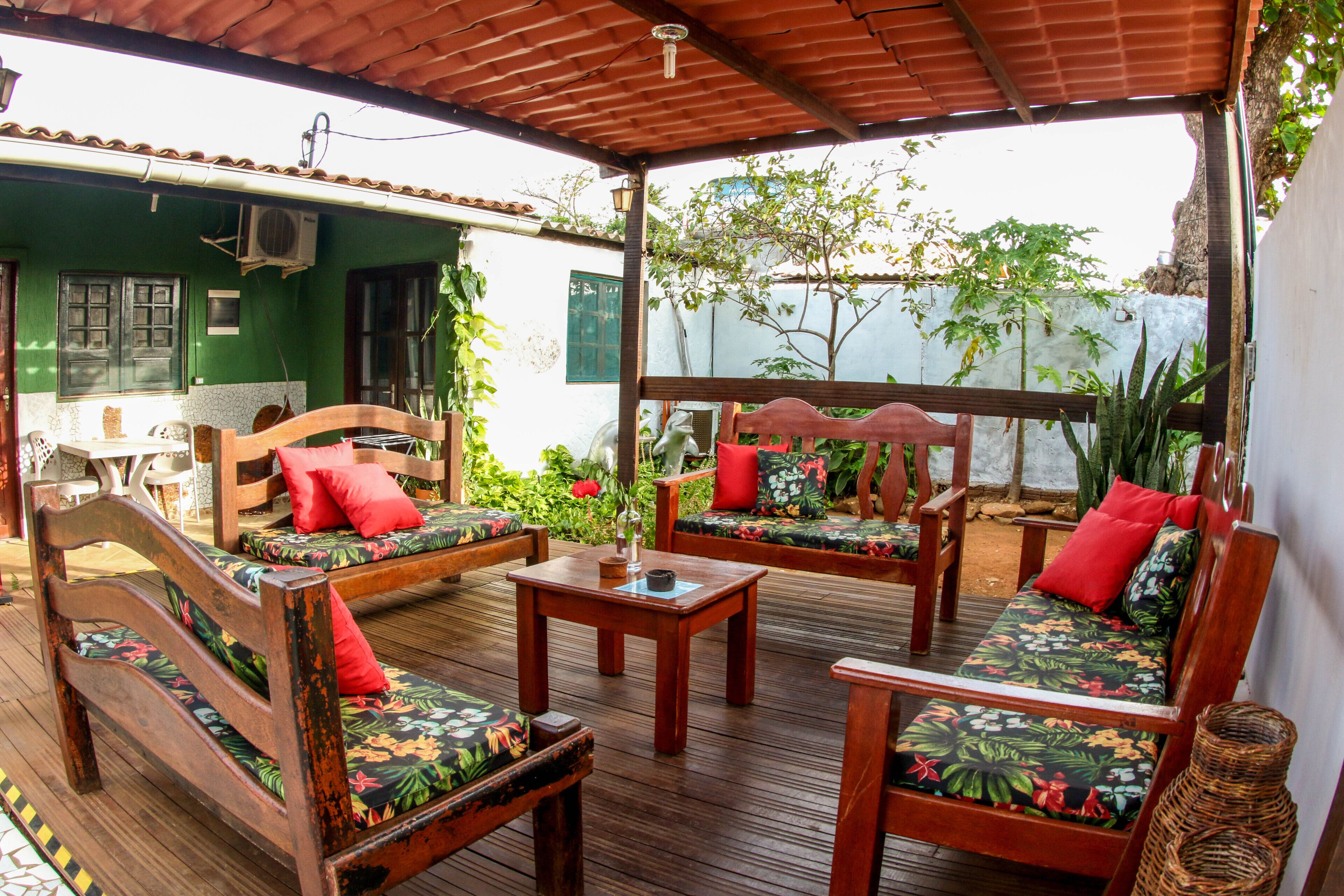 Une terrasse en bois dotée d’un espace salon couvert, comprenant deux canapés et une table.