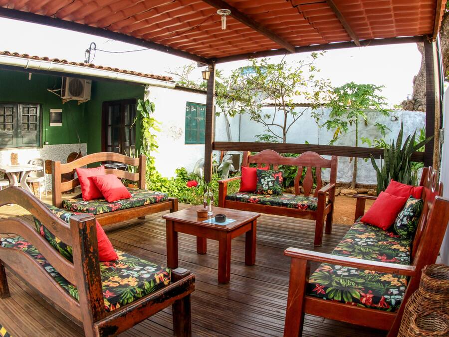 Une terrasse en bois dotée d’un espace salon couvert, comprenant deux canapés et une table.