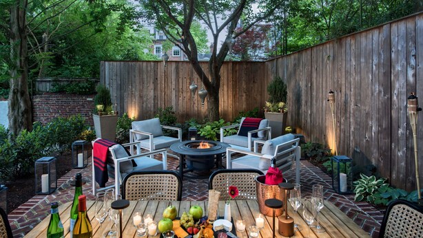 A patio with a fire pit, outdoor seating, and a table set for a meal. - The Poppy Georgetown (Washington)