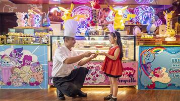 A brightly lit food stall with colorful decorations and cartoon characters.