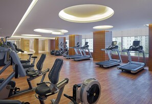 A gym with treadmills, stationary bikes, and weight machines. - Hilton Haikou (Haikou)