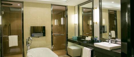 A modern bathroom with a large bathtub, a separate shower area, and a vanity with a mirror.