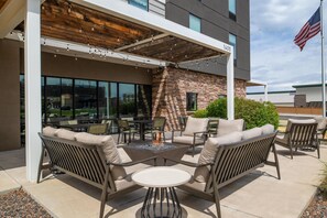 An outdoor patio with seating, a fire pit, and a view of the city. - Home2 Suites by Hilton Denver Highlands Ranch (Littleton)