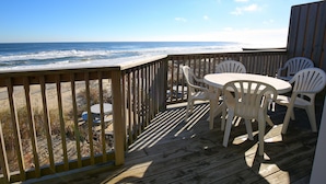 A wooden deck with a table and chairs overlooking the ocean. - Ocean Pines Resort (Kitty Hawk)
