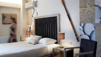 A hotel room with a bed, a nightstand, a lamp, a chair, and a wall-mounted air conditioner.
