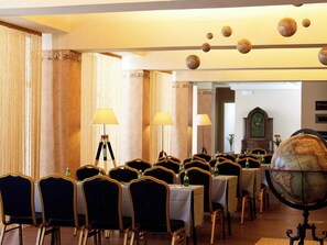 A conference room with round tables, chairs, and a globe on a stand. - Belle Helene (East Mani)