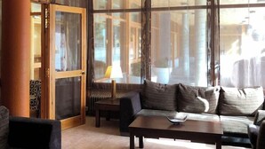 Amplia sala de estar con sofá, una mesa de centro y un ventanal que ofrece vistas al exterior.