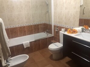 A bathroom with a bathtub, toilet, sink, and shower. - Solineu Apartments (Alp)