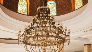 A grand interior with a large chandelier, a staircase, and a balcony with ornate railings. - Hotel Titanic Beach Spa And Aqua Park (Hurghada)