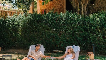 Een buitenzwembad, parasols bij het zwembad en ligstoelen