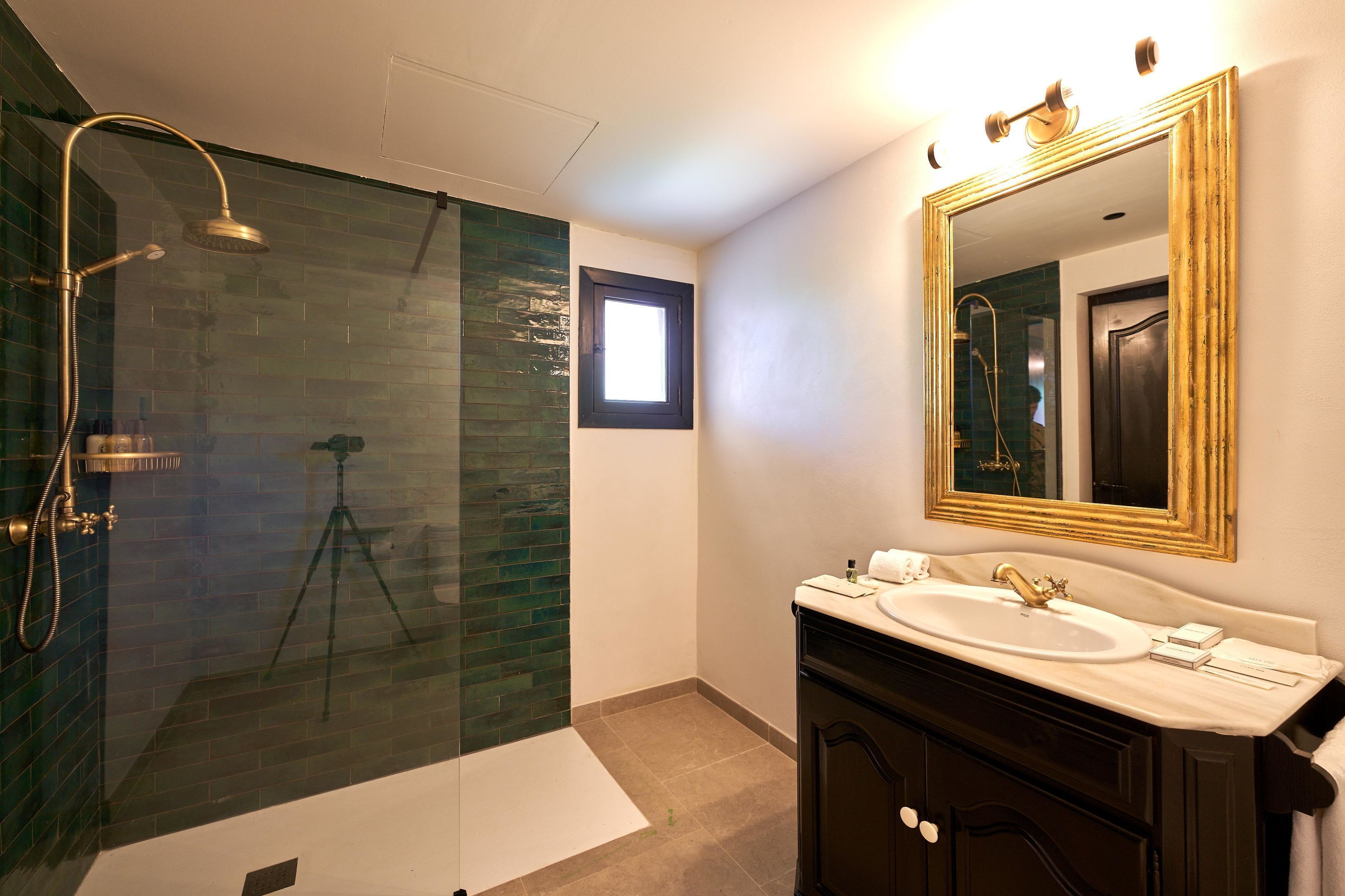Une salle de bain moderne avec une douche à parois de verre, un grand miroir et un meuble-lavabo.