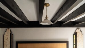 A bedroom with a large bed, a wooden ceiling, and two bedside tables with lamps.