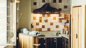 A kitchen with a wooden counter, hanging pendant lights, and a patterned backsplash. - Len KYOTO KAWARAMACHI – Hostel (Kyoto)