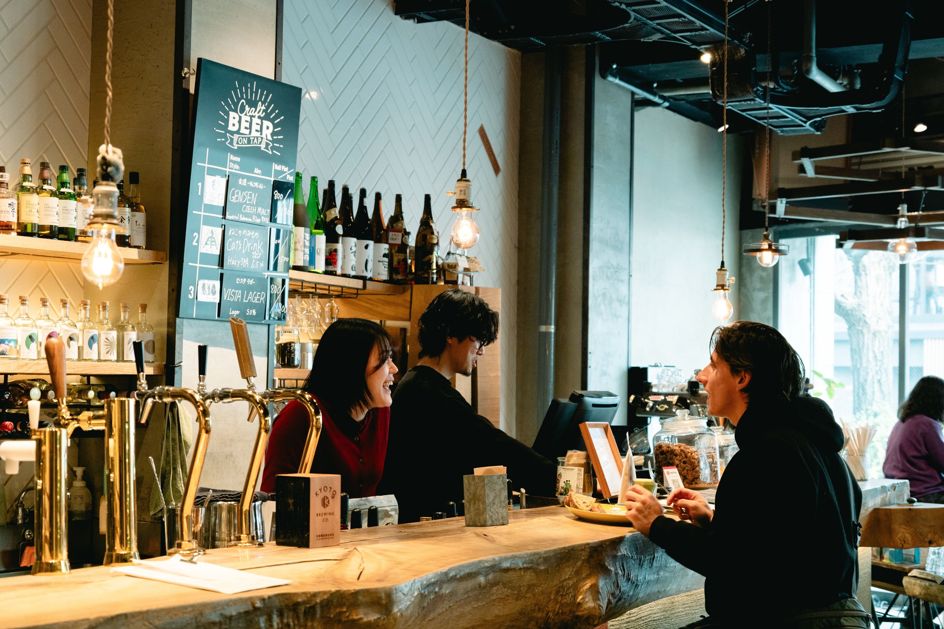 A bar with a menu board, beer taps, and a counter.
