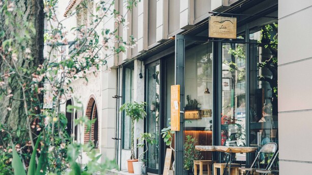 A cafe with outdoor seating, potted plants, and a signboard. - Len KYOTO KAWARAMACHI – Hostel (Kyoto)