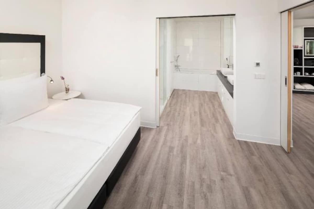 A bedroom with a bed, a bedside table, and a nightstand.