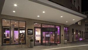 A hotel entrance with a revolving door, glass doors, and a sign reading "INSIDE FURTHER BY BELLAHANKFURT". - INNSiDE by Meliá Frankfurt Ostend (Frankfurt)