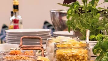 A dining table with various food items, a bottle of sauce, and a decorative rooster cutout.