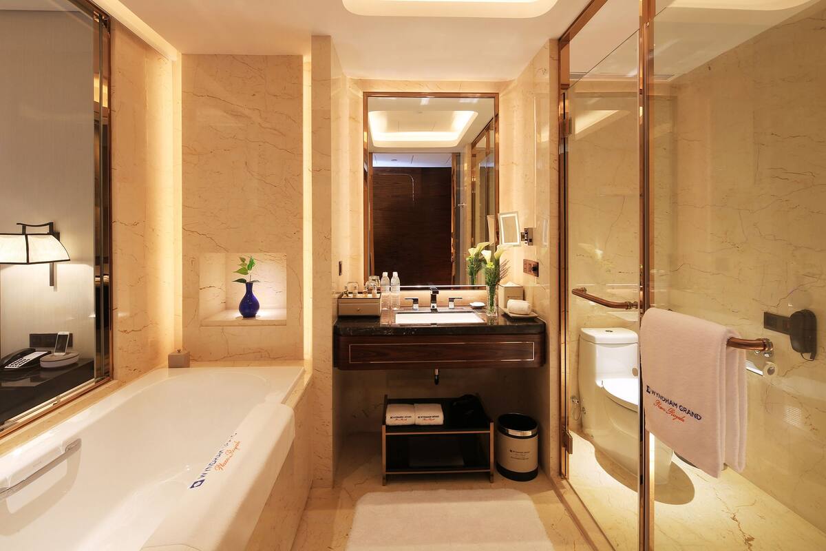 Une salle de bain moderne avec une baignoire, un meuble-lavabo avec un miroir et des toilettes.