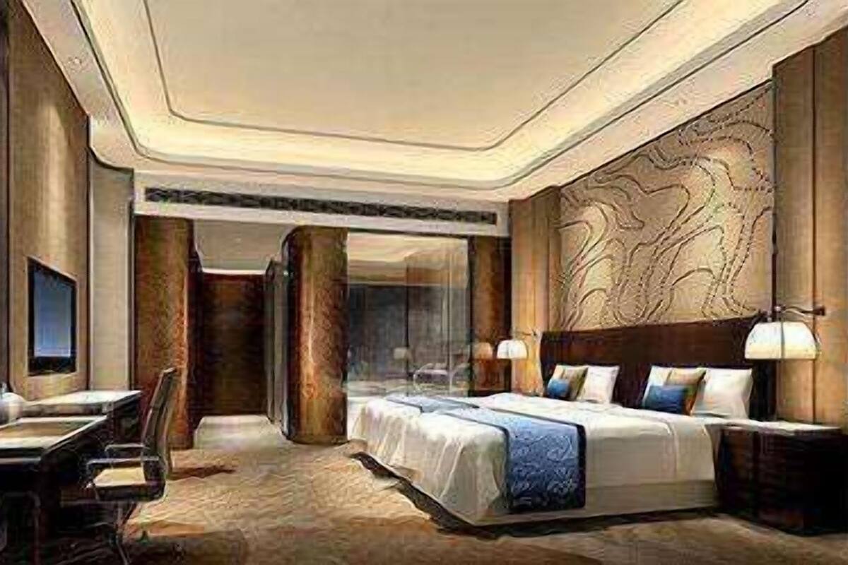 Une chambre d’hôtel avec un grand lit, un bureau et une chaise. Il y a un téléviseur accroché au mur et une fenêtre.